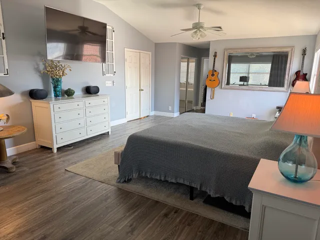 a spacious bedroom with a bed and wooden floor