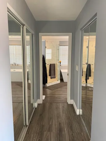 a view of a hallway with wooden floor and staircase
