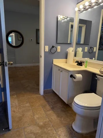 a living room with furniture a flat screen tv and kitchen view