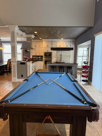 a kitchen with stainless steel appliances kitchen island granite countertop a table chairs sink and cabinets