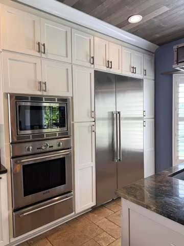 a kitchen with granite countertop a sink and cabinets
