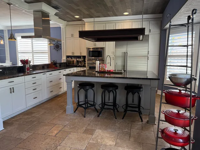 a kitchen with stainless steel appliances granite countertop a sink a stove and cabinets