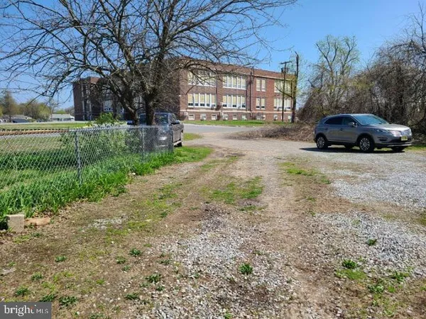 a car parked in front of a brick house with a yard