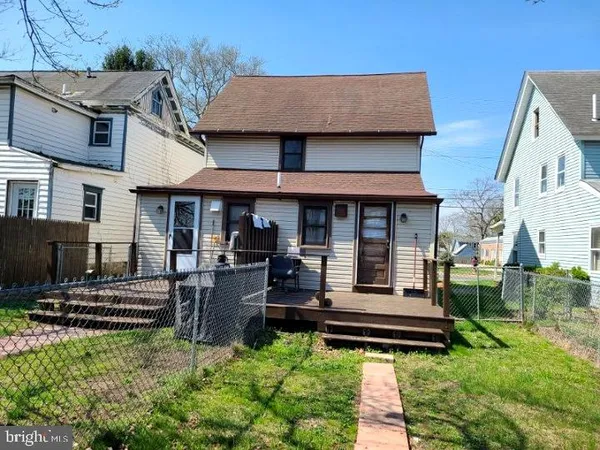 a front view of a house with garden and sitting area