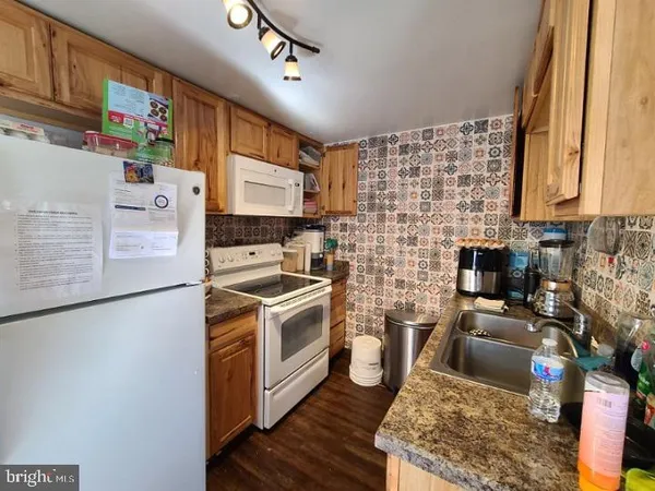 a kitchen with stainless steel appliances granite countertop a stove a sink dishwasher and a refrigerator