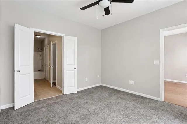 an empty room with ceiling fan and window