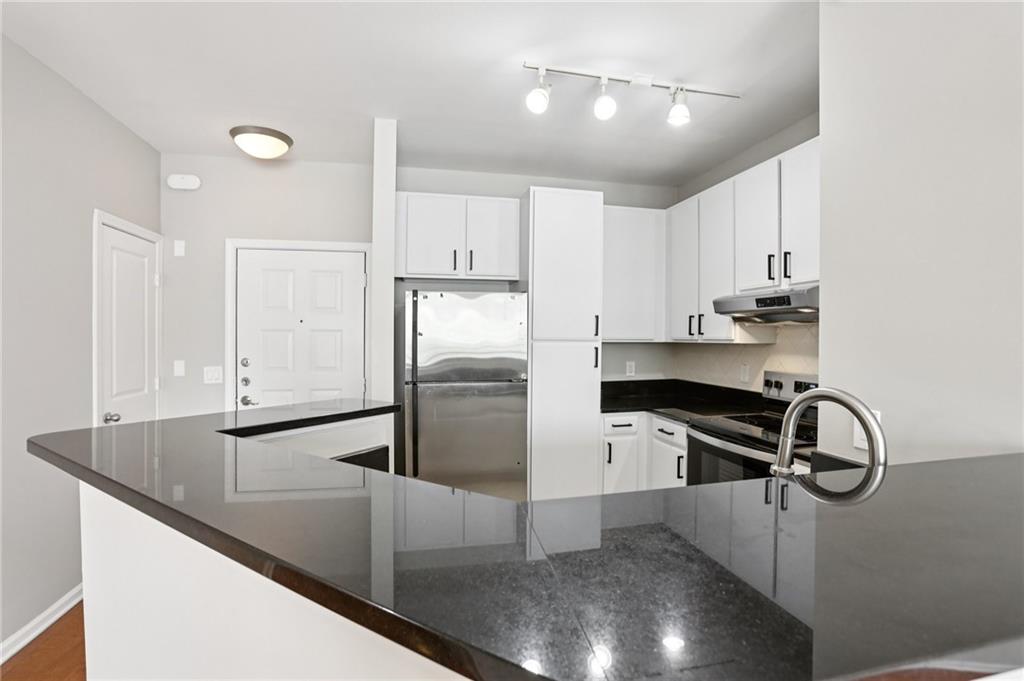 821 Ralph McGill Boulevard Northeast, Unit 3404 Atlanta, GA 30306 - Photo 6 of 18 a kitchen with kitchen island a sink appliances and cabinets