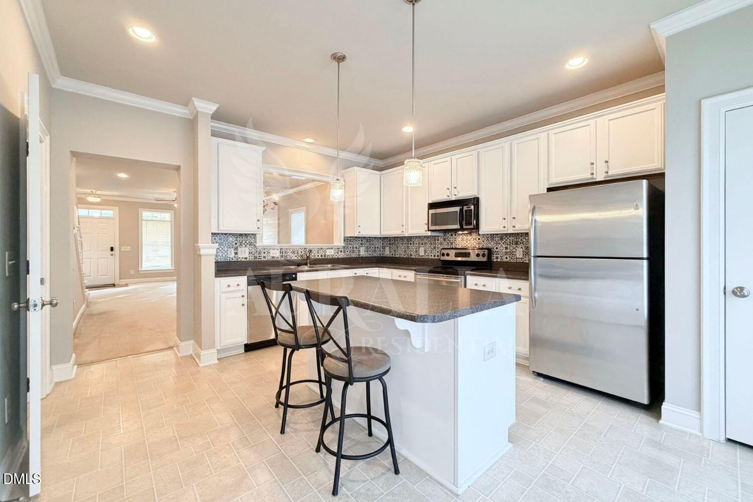 7754 ACC Boulevard Raleigh, NC 27617 - Photo 11 of 41 a kitchen with kitchen island granite countertop a refrigerator a sink a stove a microwave and island with wooden floor