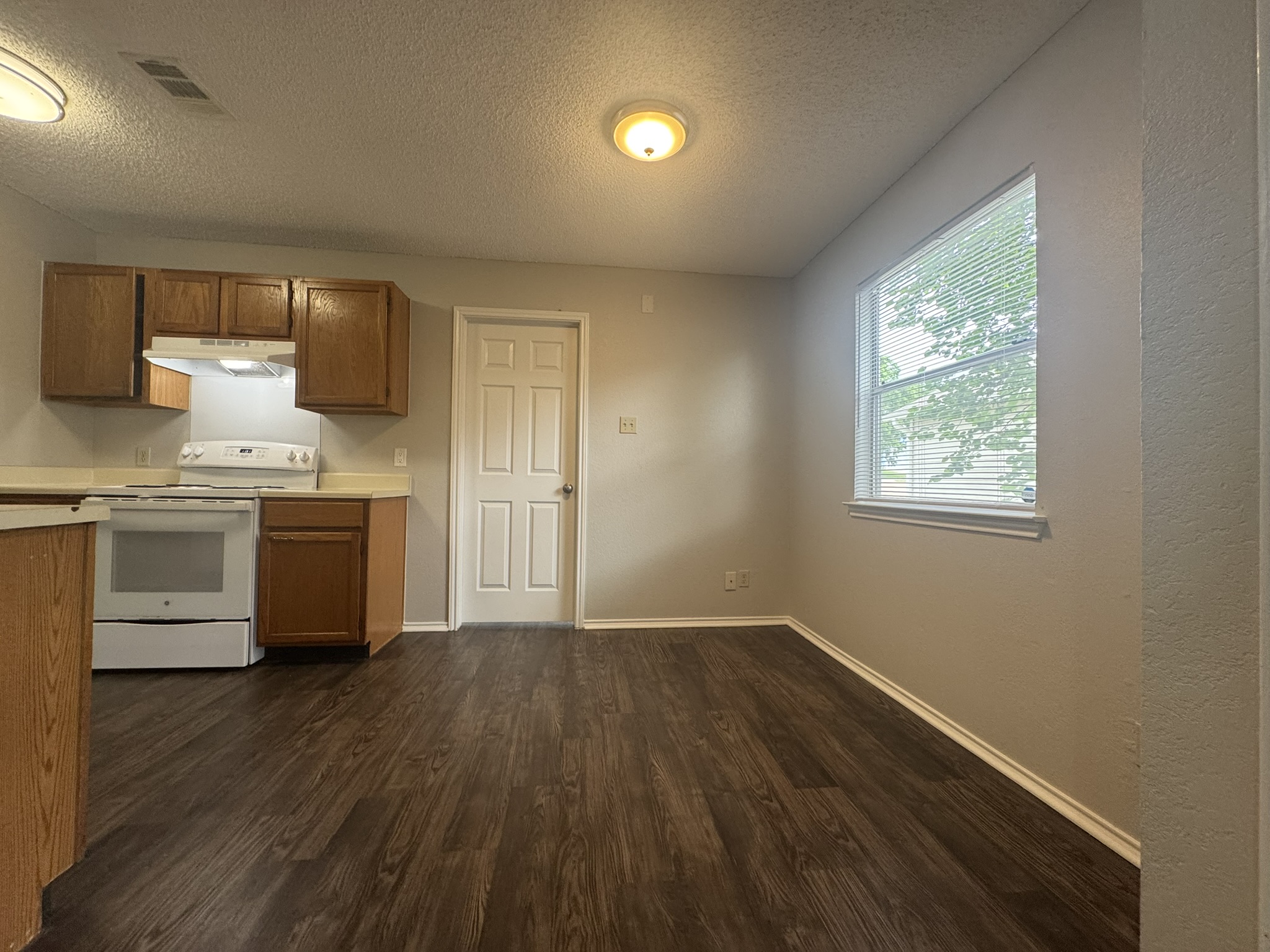 522 Cutty Trail, Unit B Lakeway, TX 78734 - Photo 7 of 20 A well-lit kitchen and dining space features rich wood flooring.
