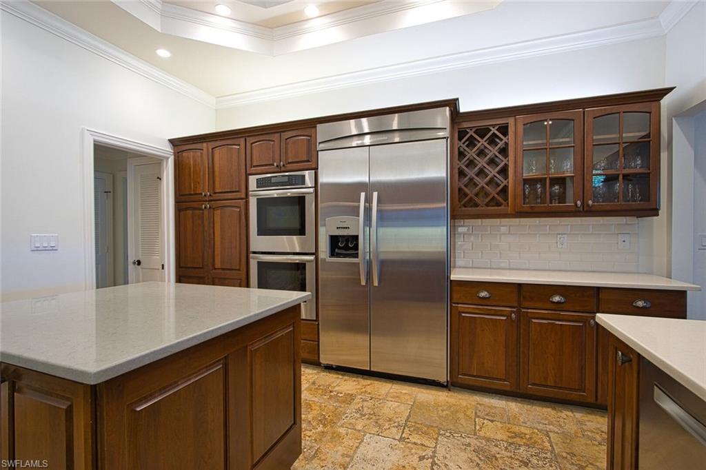 2201 Beacon Lane Naples, FL 34103 - Photo 11 of 41 a kitchen with stainless steel appliances a refrigerator and a stove