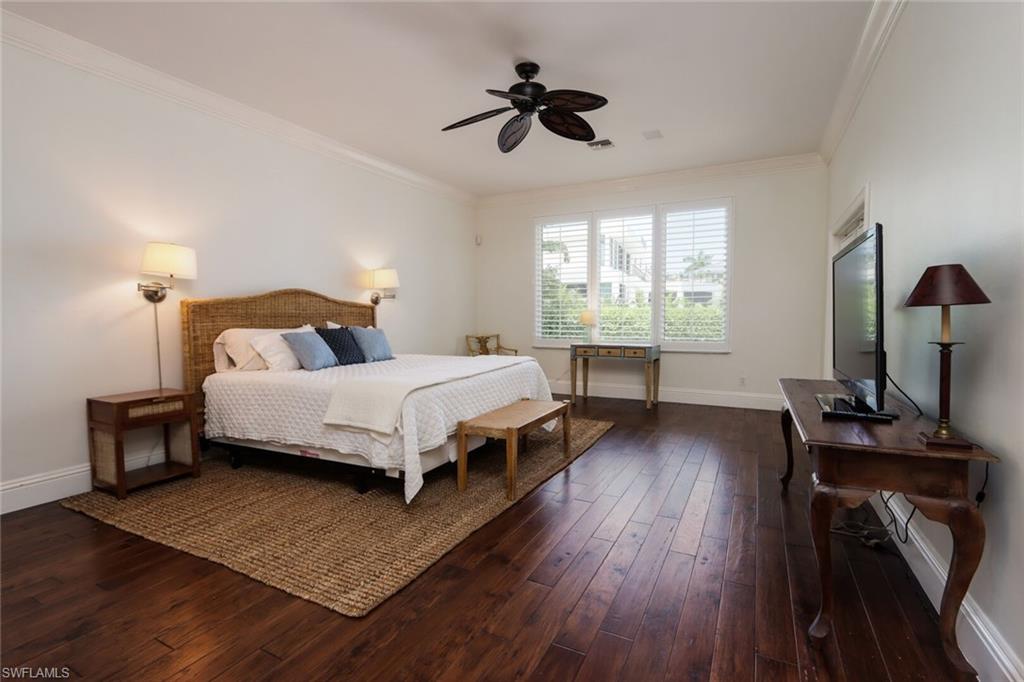 2201 Beacon Lane Naples, FL 34103 - Photo 14 of 41 a bedroom with a bed lamps and wooden floor
