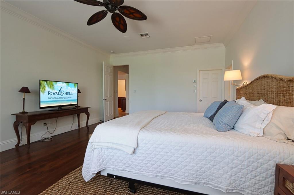 2201 Beacon Lane Naples, FL 34103 - Photo 15 of 41 a bedroom with a bed and a chandelier