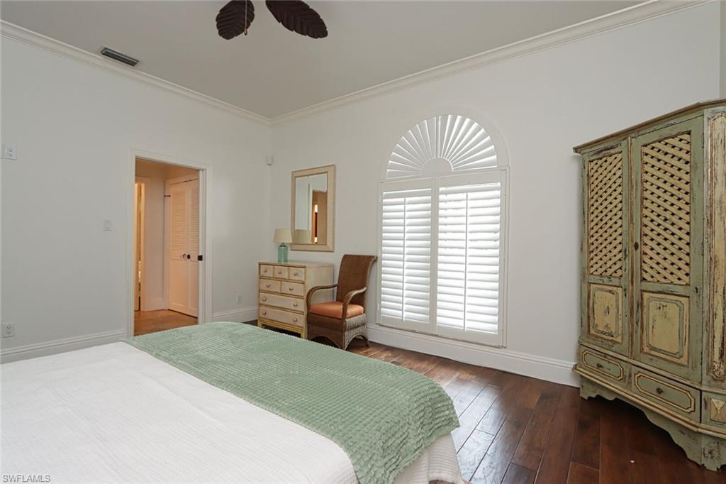 2201 Beacon Lane Naples, FL 34103 - Photo 25 of 41 a bedroom with a bed and a chandelier