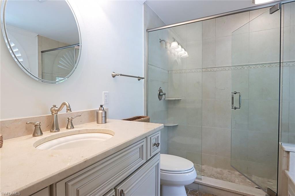 2201 Beacon Lane Naples, FL 34103 - Photo 26 of 41 a bathroom with a granite countertop sink toilet a mirror and shower