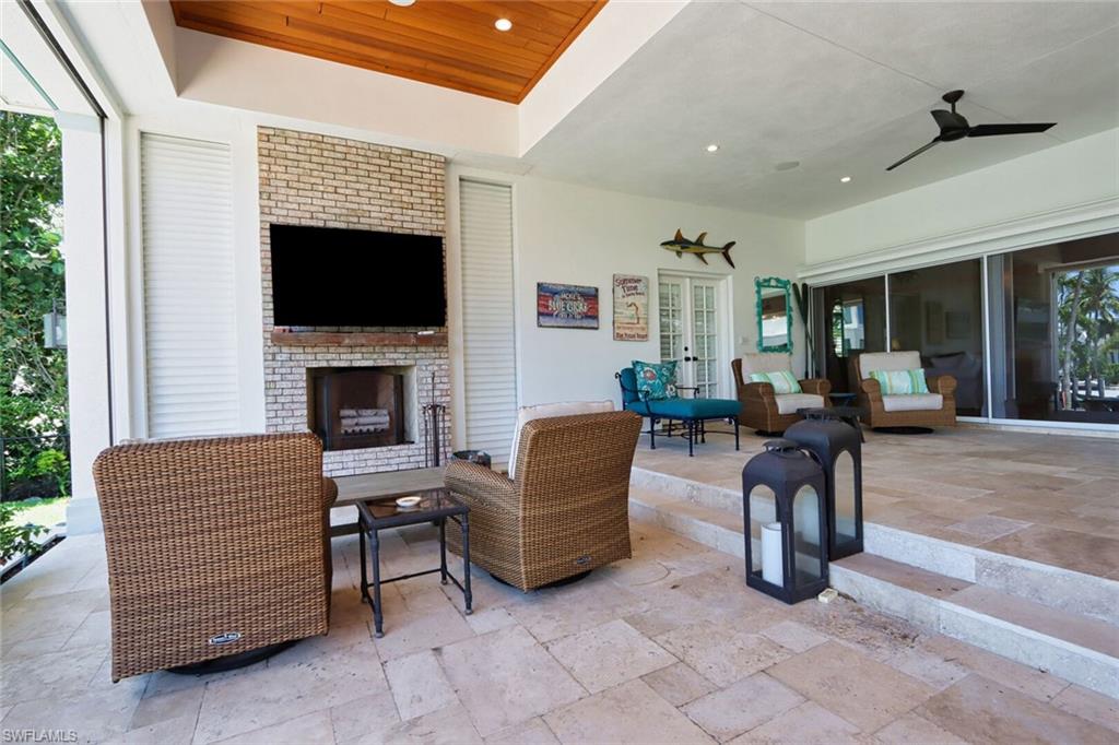 2201 Beacon Lane Naples, FL 34103 - Photo 29 of 41 a living room with furniture a flat screen tv and a fireplace