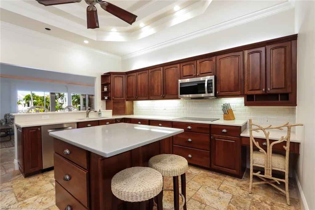 2201 Beacon Lane Naples, FL 34103 - Photo 10 of 41 a kitchen with a stove a sink and a microwave