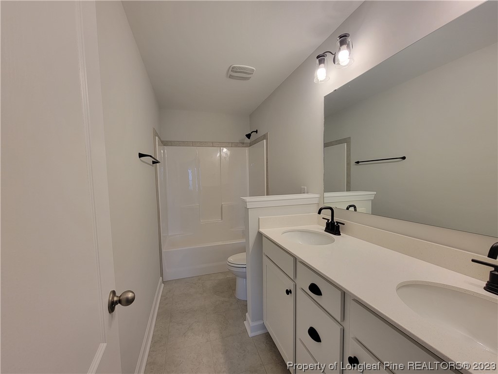 187 Timber Skip Drive Spring Lake, NC 28390 - Photo 15 of 20 a bathroom with a sink double vanity and a mirror