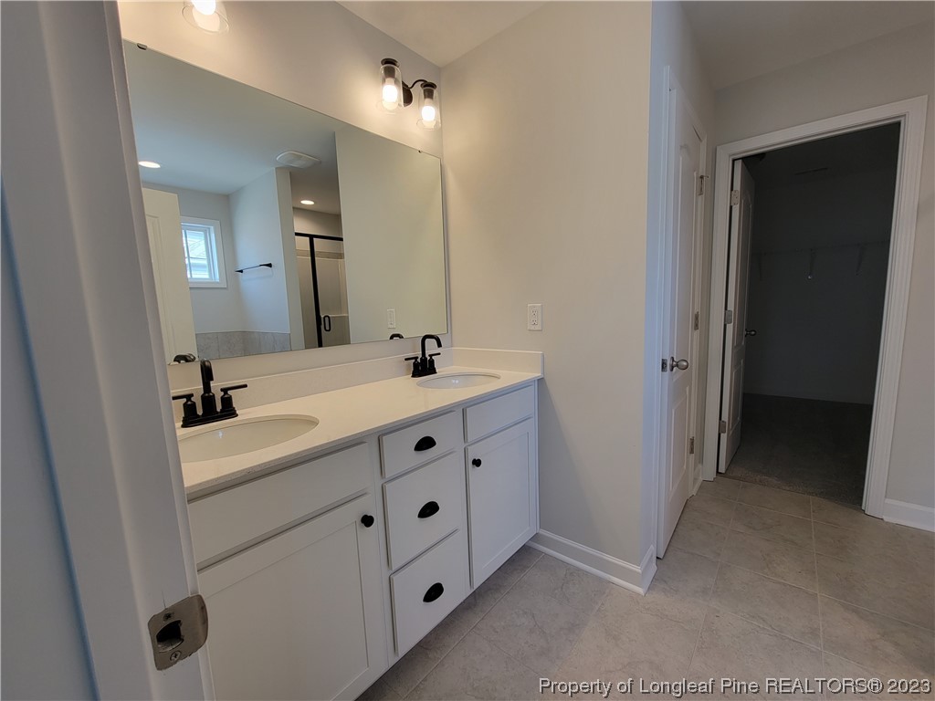 187 Timber Skip Drive Spring Lake, NC 28390 - Photo 10 of 20 a bathroom with a double vanity sink and mirror