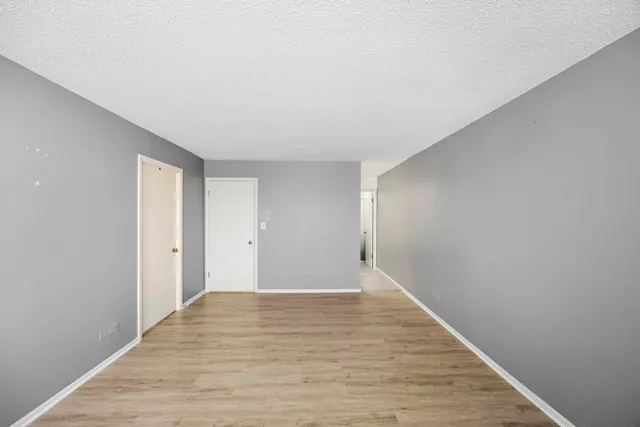 a view of an empty room with wooden floor