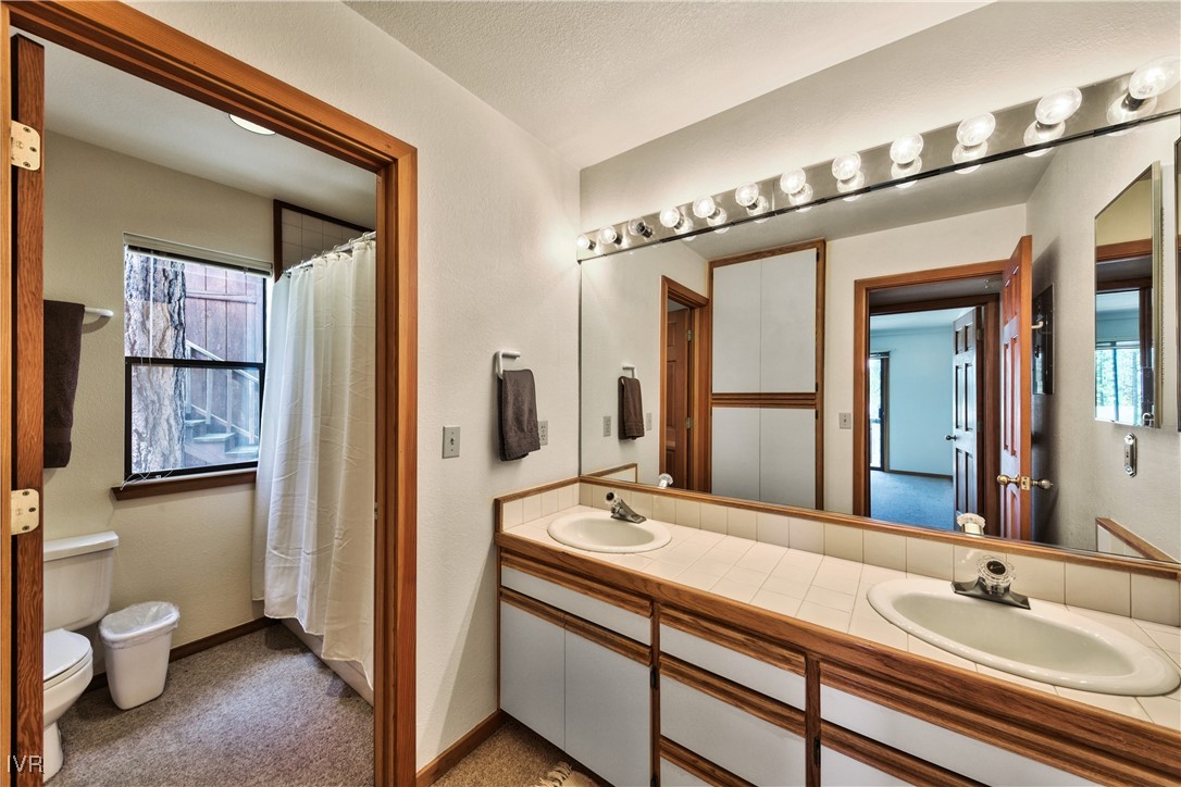 609 Lariat Circle, Unit 2 Incline Village, NV 89451 - Photo 16 of 24 a bathroom with a granite countertop sink a toilet and a mirror