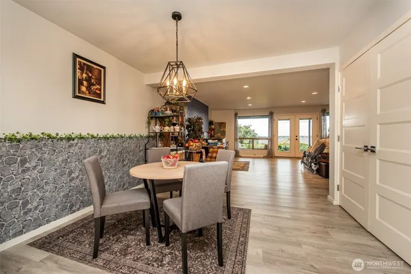 a view of a dining room and livingroom with furniture wooden floor a chandelier