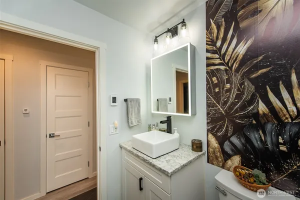 a bathroom with a granite countertop sink a mirror and a shower