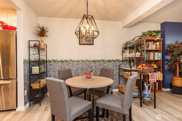 a dining room with furniture a chandelier and wooden floor
