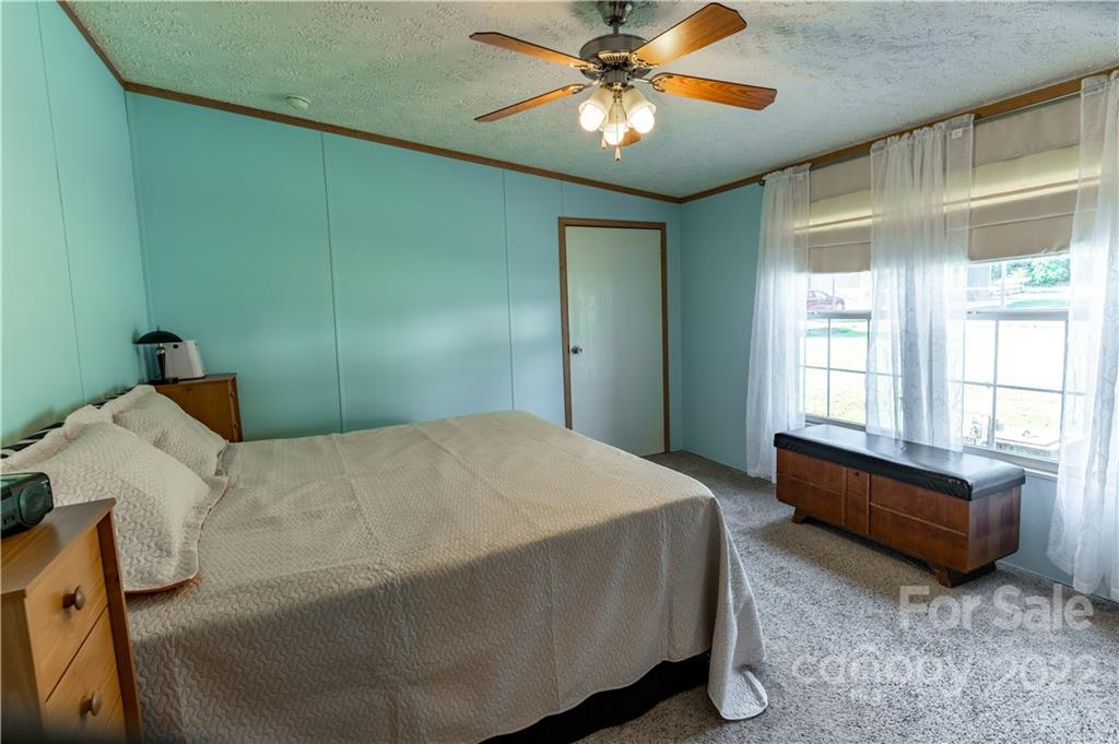 48 Lynn Estate Road Hendersonville, NC 28792 - Photo 13 of 23 a bedroom with a bed and a chandelier