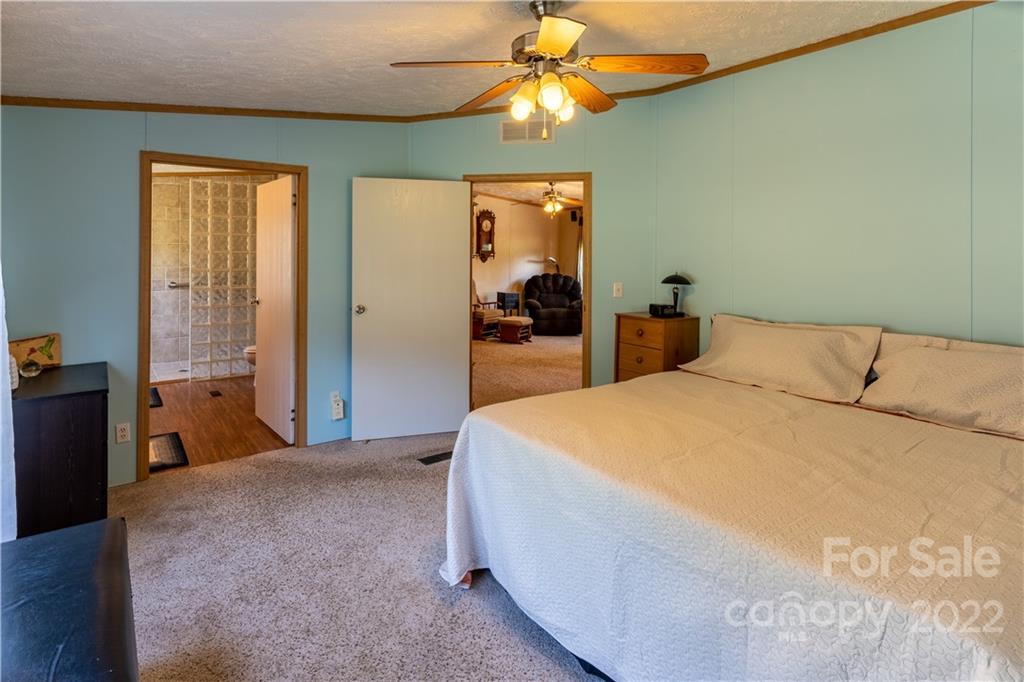 48 Lynn Estate Road Hendersonville, NC 28792 - Photo 14 of 23 a bedroom with a bed and a chandelier