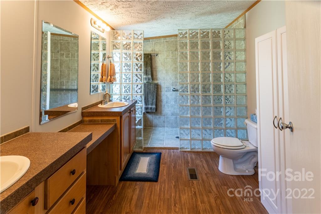 48 Lynn Estate Road Hendersonville, NC 28792 - Photo 17 of 23 a bathroom with a sink a toilet a mirror and shower