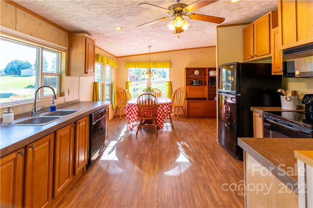 48 Lynn Estate Road Hendersonville, NC 28792 - Photo 9 of 23 a kitchen with stainless steel appliances granite countertop a stove and a view of living room
