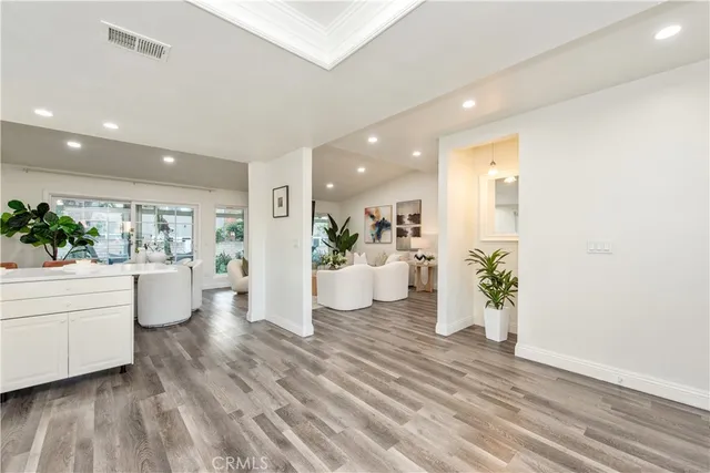 a room with wooden floor and a potted plant