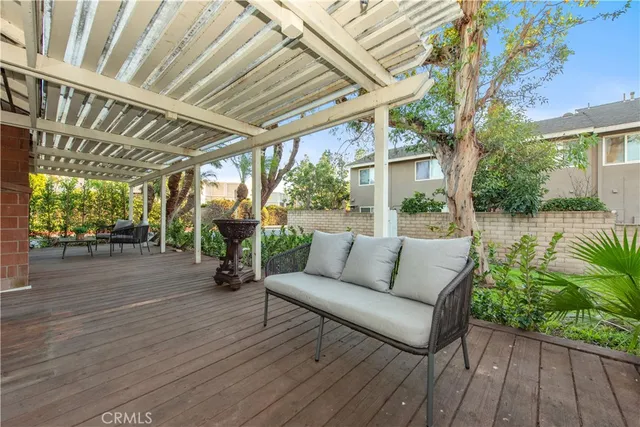 a view of a patio with couches plants and wooden floor