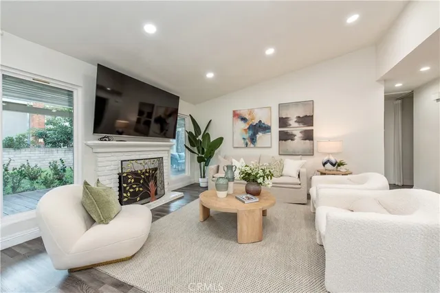 a living room with furniture a flat screen tv and a fireplace