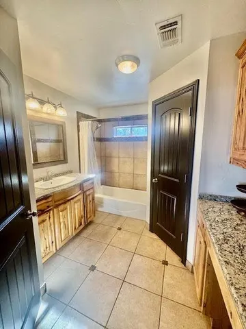 a bathroom with a granite countertop sink a large mirror and a shower
