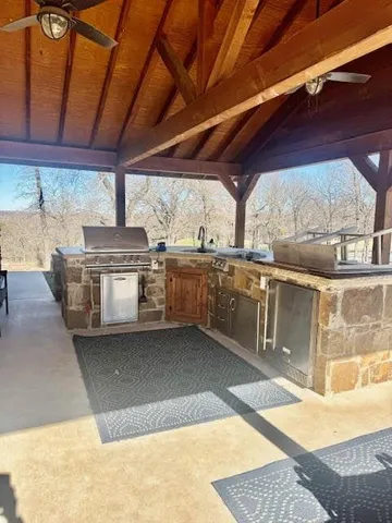 a view of a kitchen with stainless steel appliances granite countertop a stove a sink and a microwave