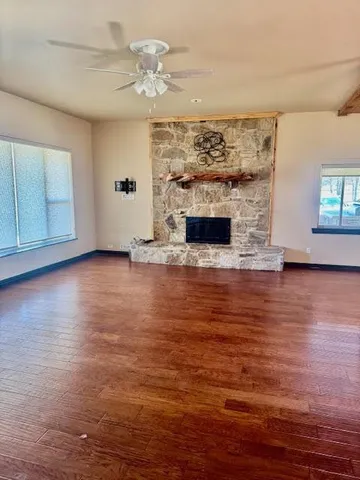 wooden floor fireplace and windows in an empty room