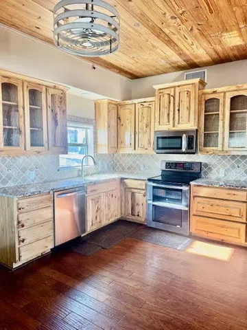 a kitchen with stainless steel appliances granite countertop a stove sink and cabinets