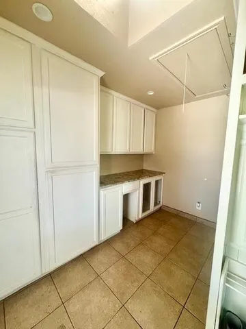 a kitchen with a refrigerator and white cabinets