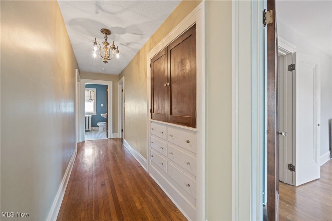 24510 Lake Road Bay Village, OH 44140 - Photo 36 of 45 Corridor with hardwood / wood-style floors, a chandelier, and radiator heating unit