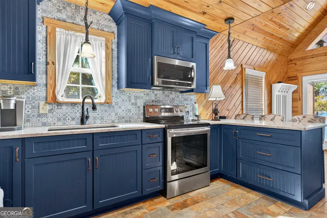 a kitchen with stainless steel appliances granite countertop a sink stove and microwave
