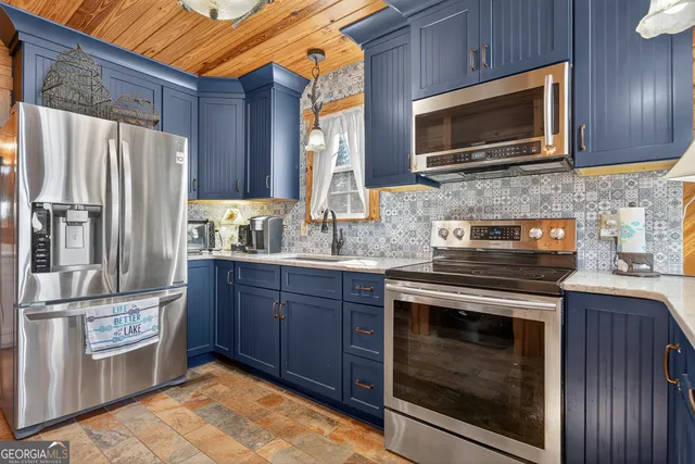 a kitchen with stainless steel appliances granite countertop a stove microwave refrigerator and sink