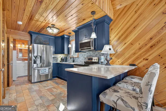 a kitchen with stainless steel appliances granite countertop a sink a stove counter space and cabinets