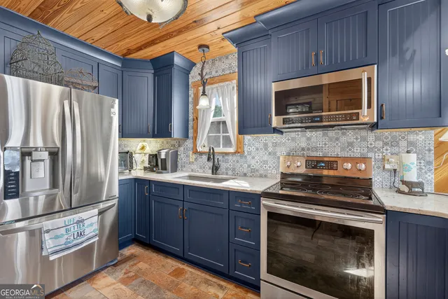 a kitchen with stainless steel appliances granite countertop a stove microwave and refrigerator