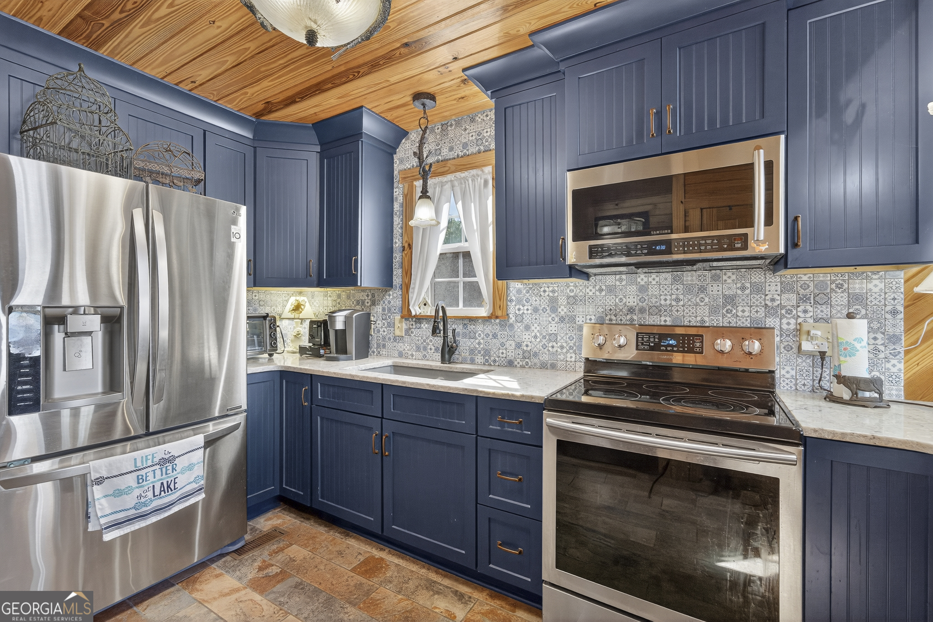 955 Barbara Point Road Sparta, GA 31087 - Photo 16 of 54 a kitchen with stainless steel appliances granite countertop a stove microwave and refrigerator