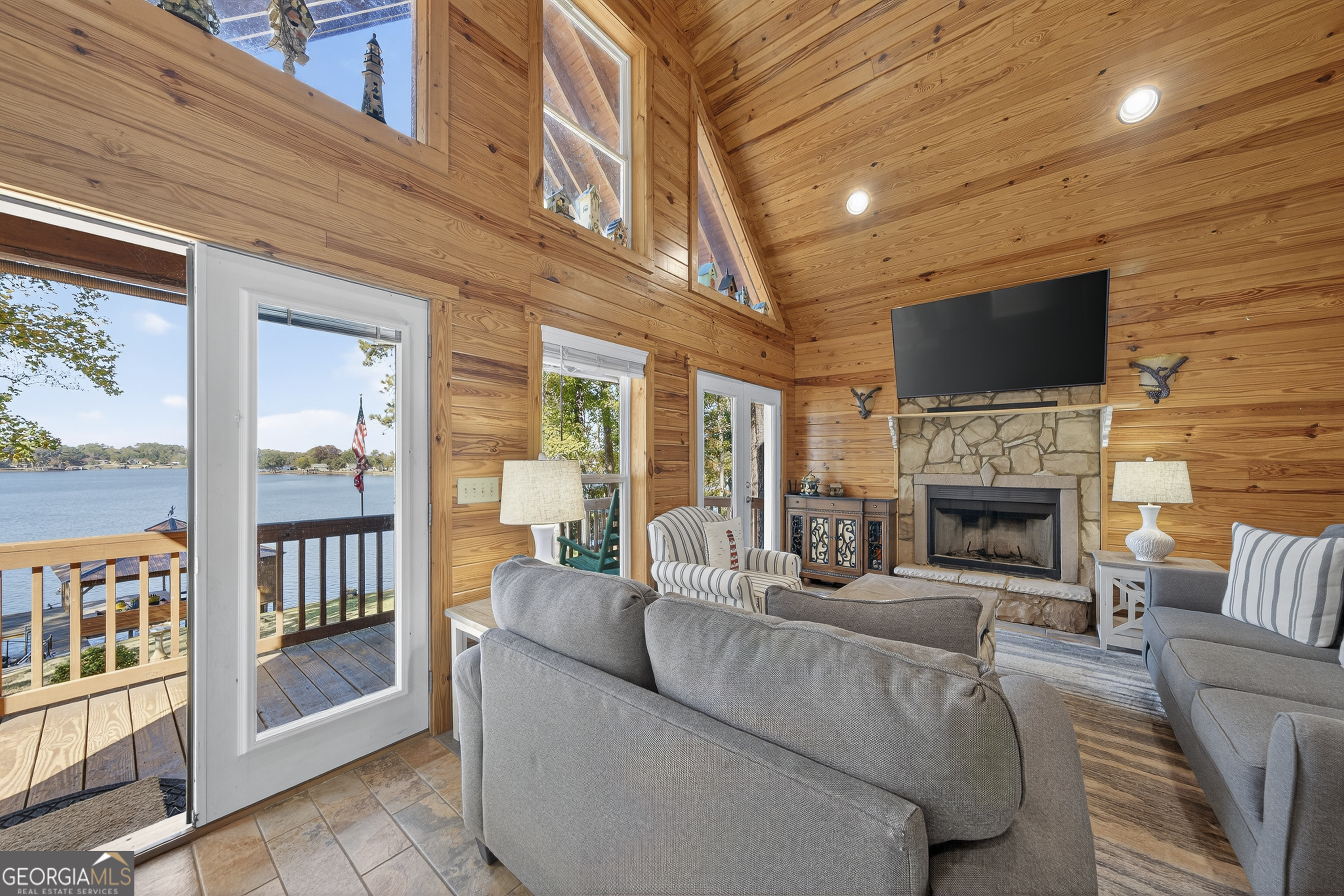 955 Barbara Point Road Sparta, GA 31087 - Photo 6 of 54 a living room with furniture a flat screen tv and a fireplace