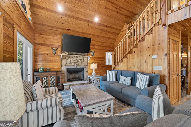 a living room with furniture a flat screen tv and a fireplace