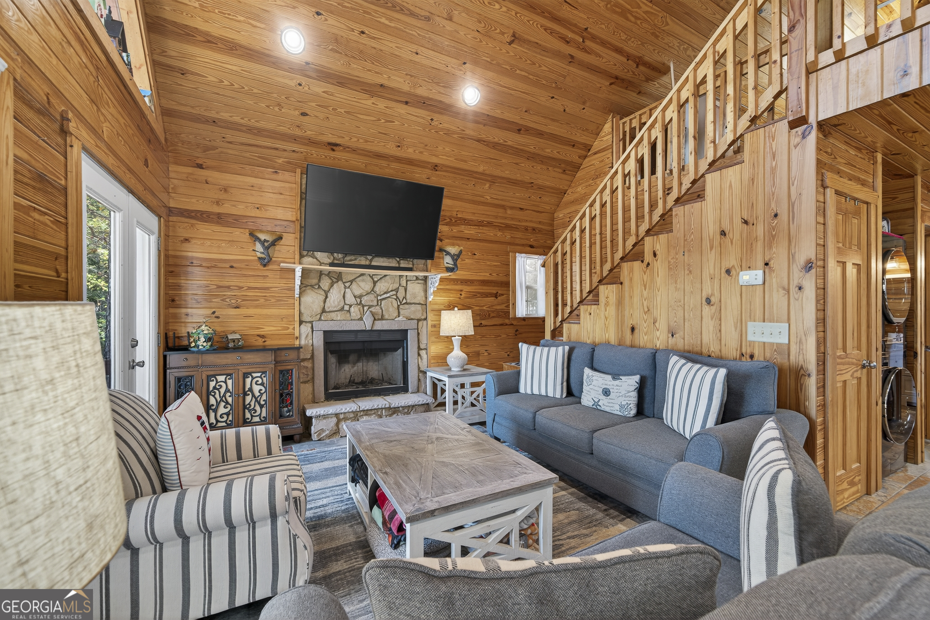955 Barbara Point Road Sparta, GA 31087 - Photo 9 of 54 a living room with furniture a flat screen tv and a fireplace