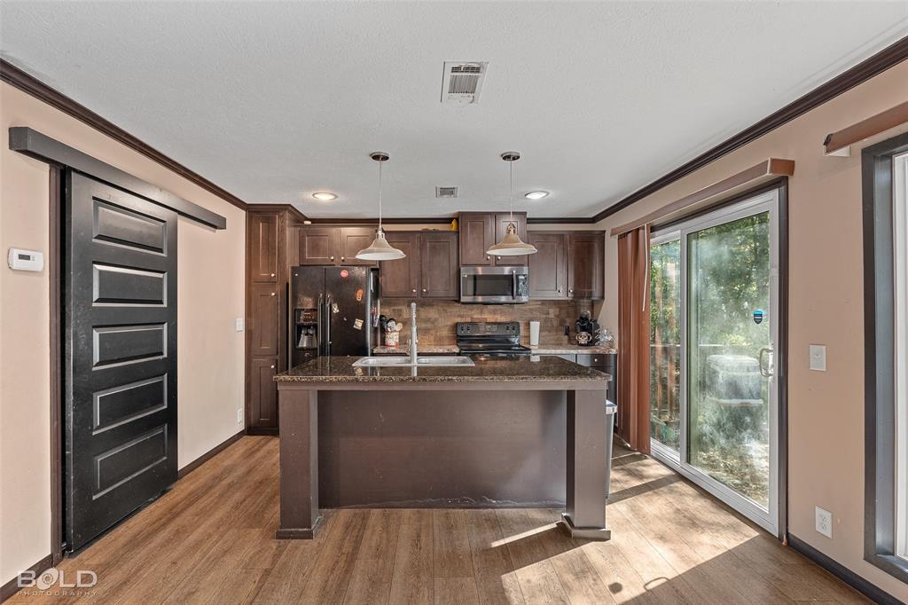 9489 Capps City Road Rodessa, LA 71069 - Photo 19 of 34 a kitchen with kitchen island a counter top space a sink stainless steel appliances and cabinets