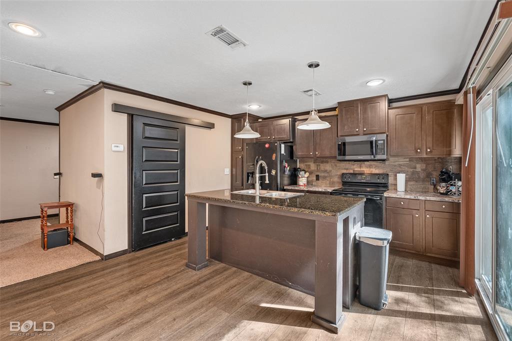 9489 Capps City Road Rodessa, LA 71069 - Photo 20 of 34 a kitchen with kitchen island stainless steel appliances a stove refrigerator and cabinets